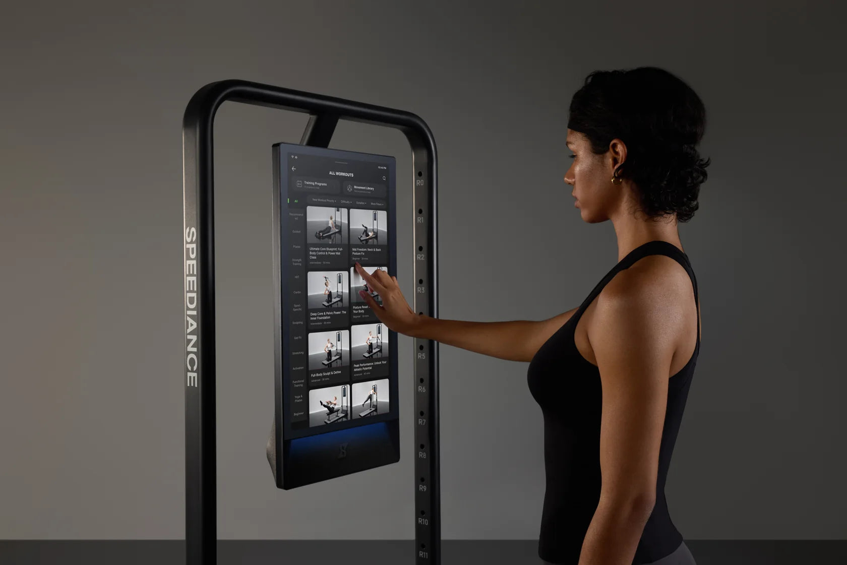 Eine Frau wählt ein Workout auf dem Touchscreen von Gym Monster 3